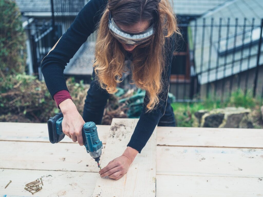 woman working outside with a drill