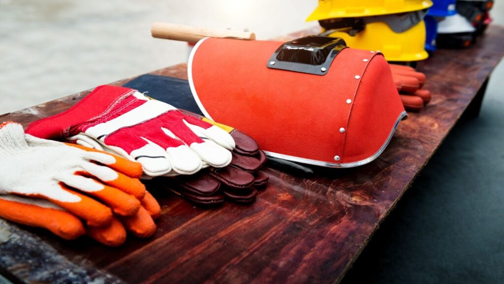 Welding gloves and helmet on a wooden table