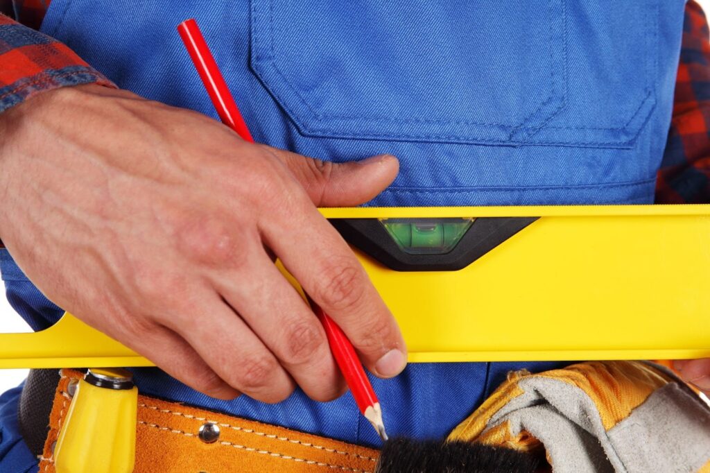 A man with a spirit level and a red pen