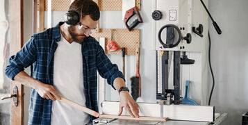 Professional carpenter working with sawing machine