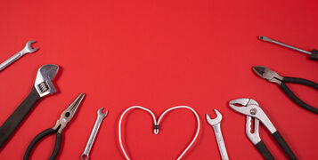 Construction,Tools,For,Repairs,And,Heart-shaped,Wire,On,A,Red