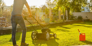 Man,Mowing,Lawn,With,Push,Mower,At,Miday,,Gas,Tank