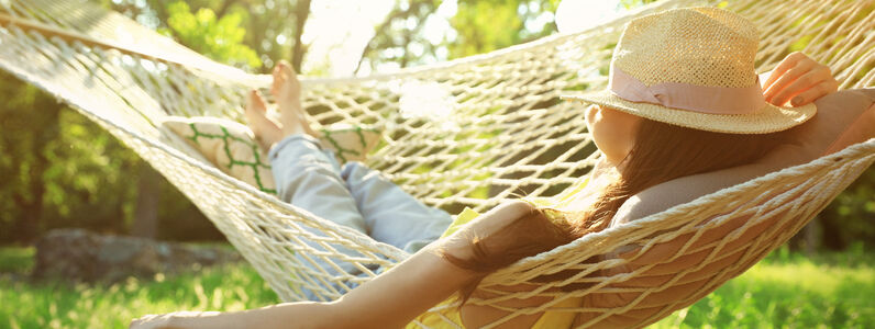 Young,Woman,With,Hat,Resting,In,Comfortable,Hammock,At,Green